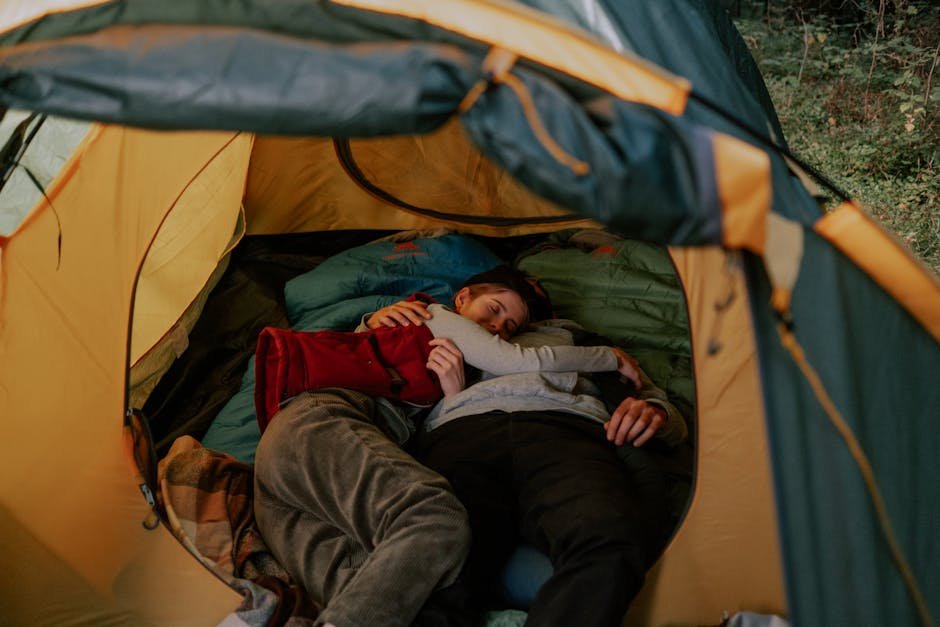 A cozy moment of a couple cuddling inside a tent, reflecting outdoor relaxation.