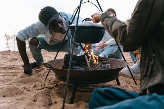 People enjoying a camping trip, cooking over a campfire by the lakeside.